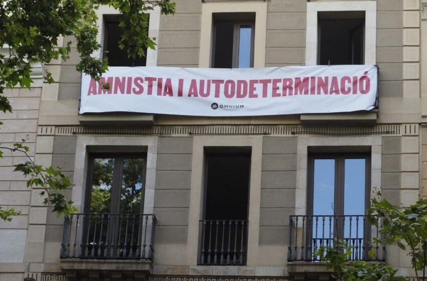  Òmnium despliega una pancarta ante el Liceu para reclamar a Sánchez amnistía y autodeterminación