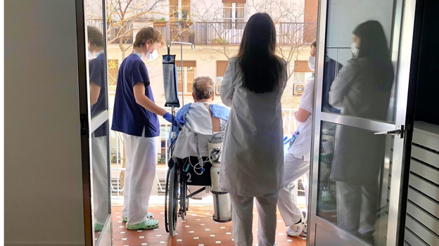 lberto Peñuelas, estudiante de 4º de Enfermería de la Universidad Francisco de Vitoria, acompañando a un paciente de UCI durante los 'Paseos que curan'